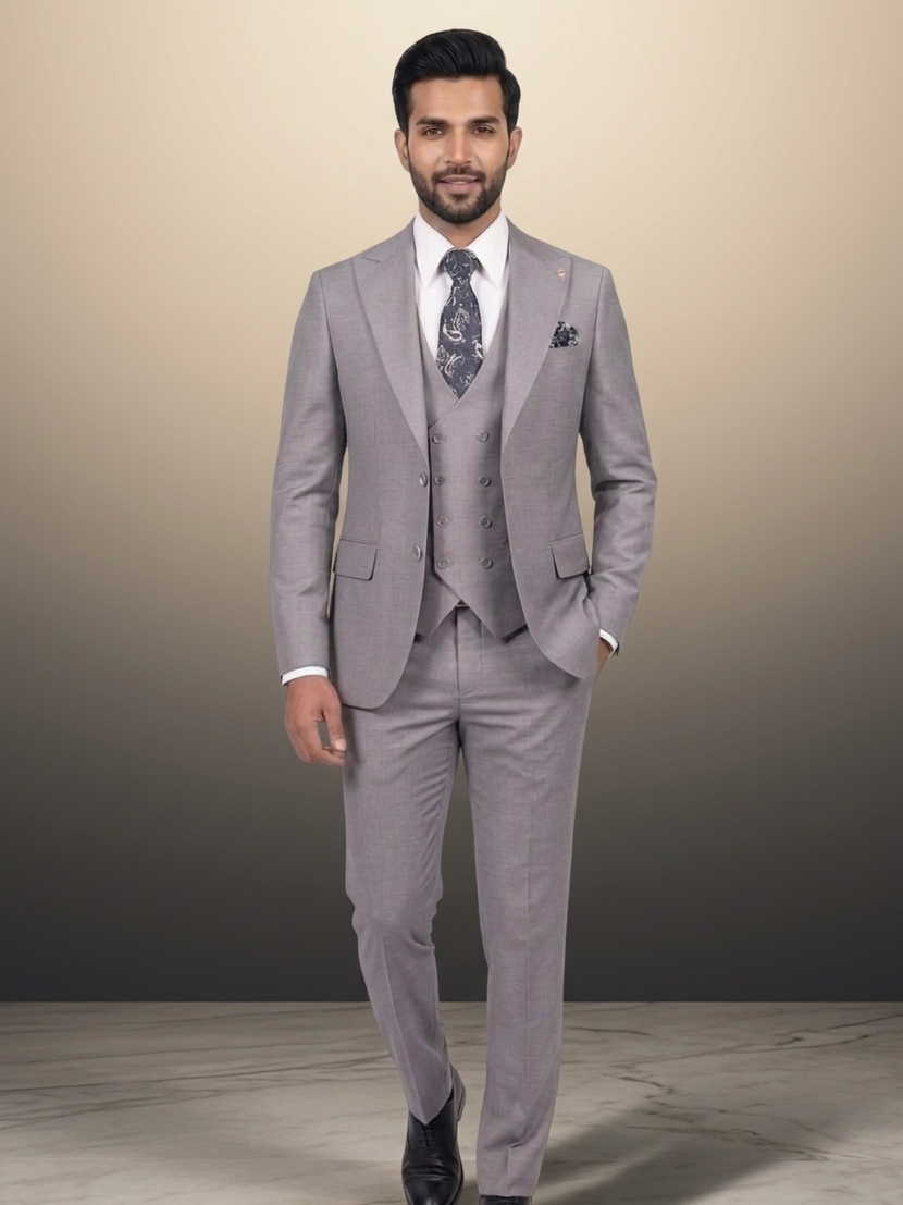 Man wearing a gray suit with a white shirt and patterned tie on a neutral background